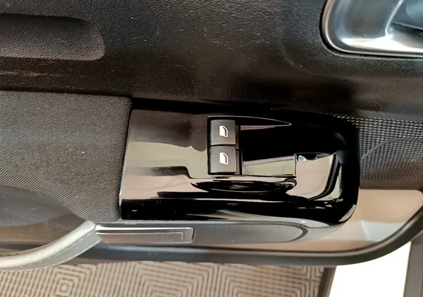 Gros plan sur les commandes de lève-vitres électriques côté conducteur d'une Citroën C3 blanche de 2021.