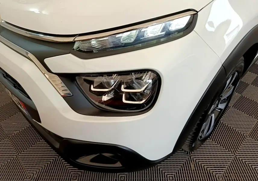 Gros plan sur l’avant droit blanc d’une Citroën C3 2021 avec phares LED et détails chromés distinctifs.