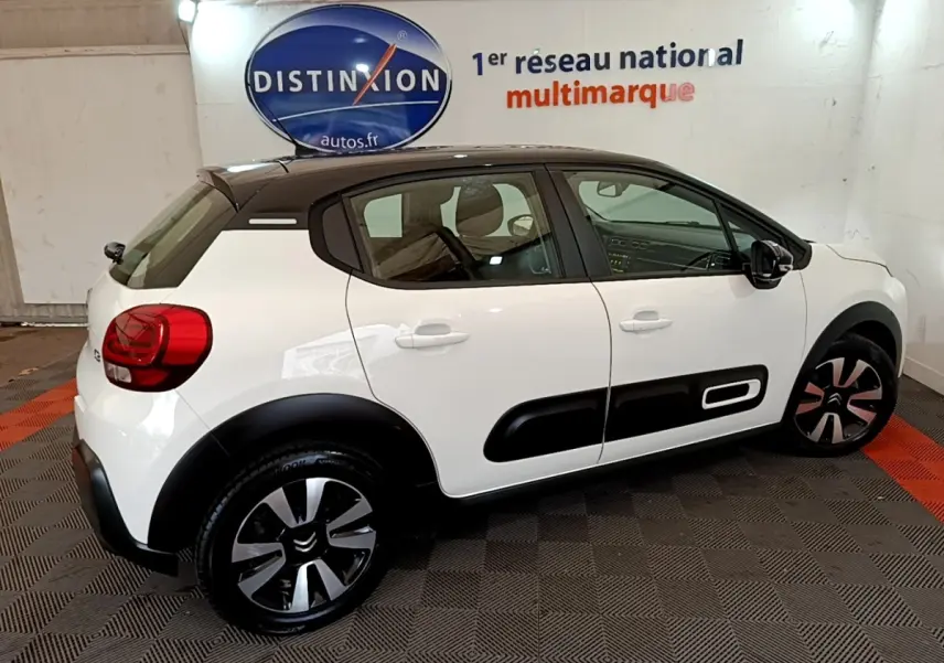 Citroën C3 blanc vue de profil droit, toit noir, avec protections latérales noires et jantes stylisées.