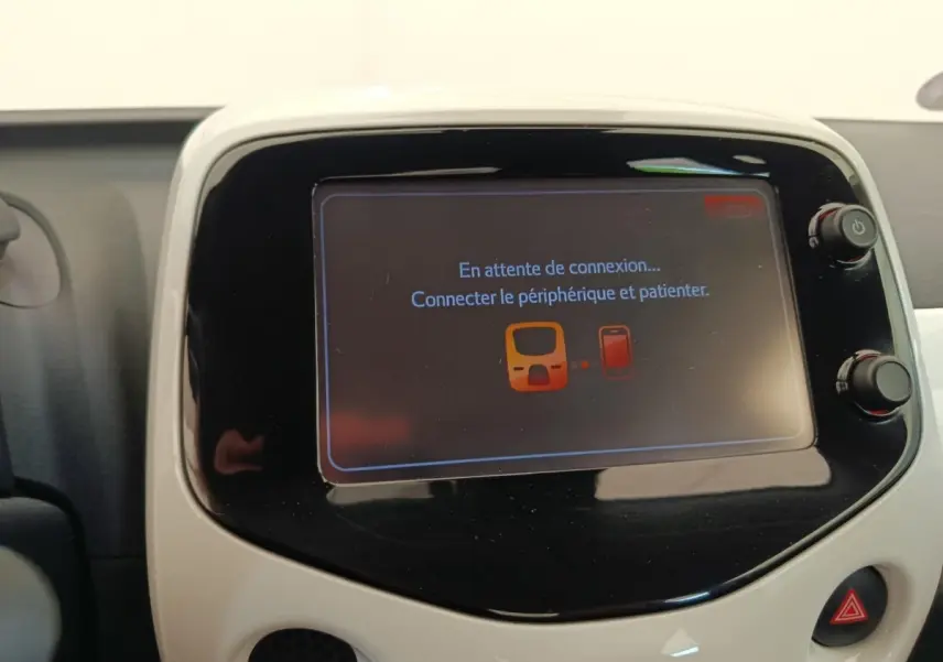 Écran tactile central blanc de la Toyota Aygo 2016 affichant un message de connexion Bluetooth en attente.