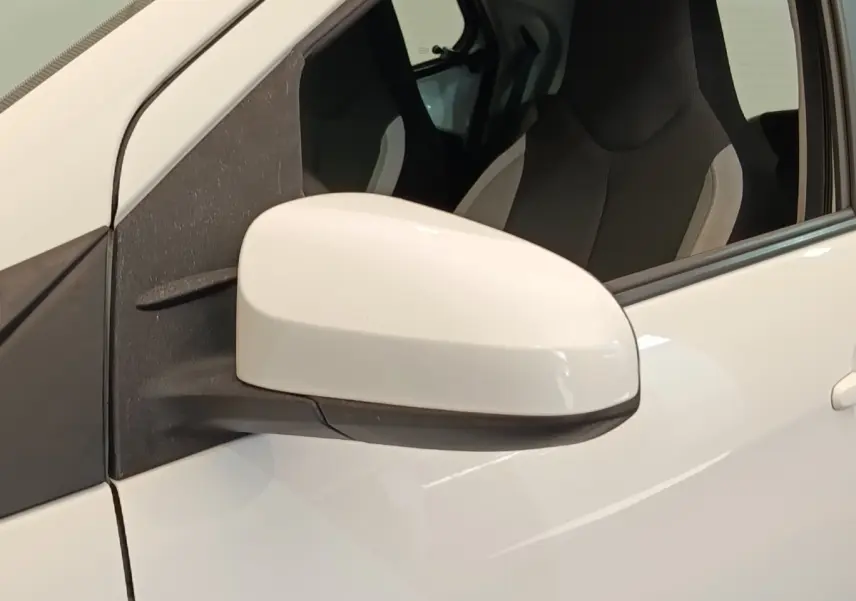 Gros plan sur le rétroviseur extérieur gauche blanc d'une Toyota Aygo 2016, avec siège conducteur visible en arrière-plan.