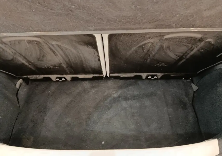 Vue du coffre arrière ouvert de la Toyota Aygo blanc 2016, montrant l'espace de rangement avec banquette rabattue.