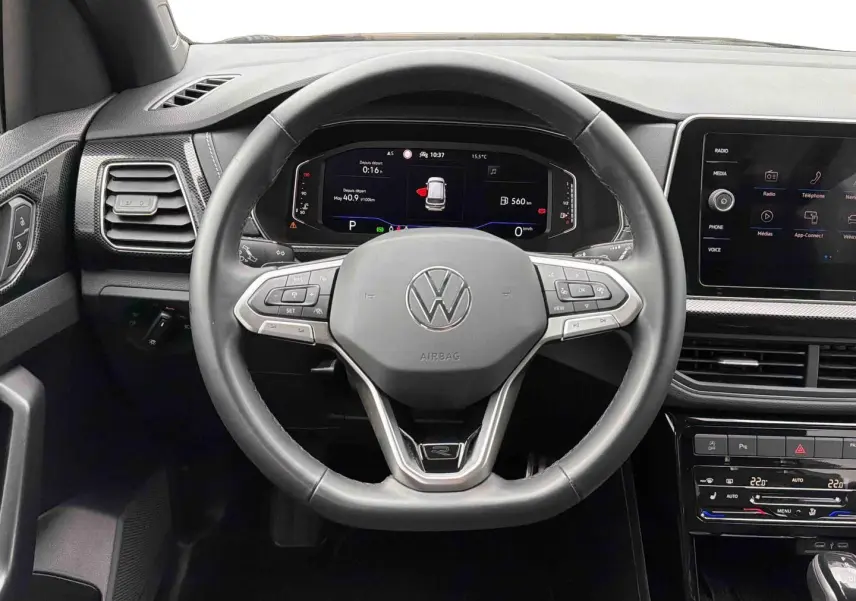 Vue intérieure centrée sur le volant cuir multifonction et le tableau de bord digital du Volkswagen T-Cross gris.