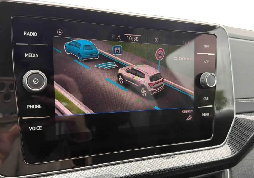 Écran tactile intérieur montrant l'aide au stationnement avec vue 3/4 arrière du Volkswagen T-Cross gris.