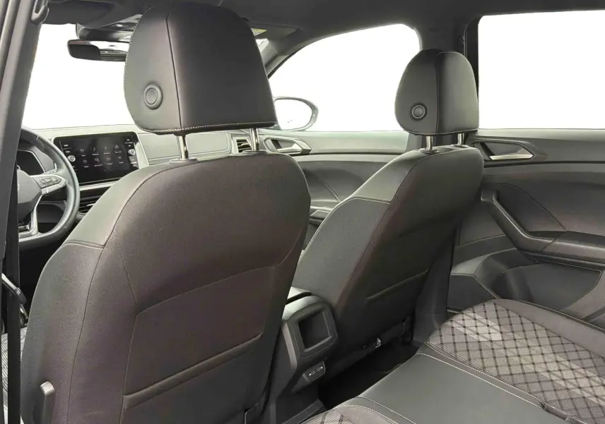 Vue intérieure arrière du Volkswagen T-Cross 2025 montrant les sièges avant noirs et la banquette arrière avec tissu à motif.