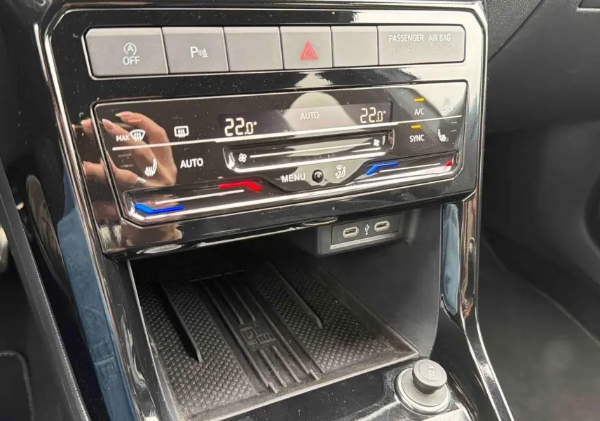 Gros plan sur la console centrale noire du Volkswagen T-Cross 2025 avec commandes climatisation digitale et ports USB-C.