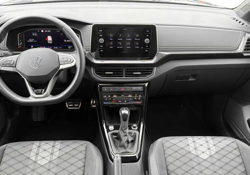 Vue intérieure avant du Volkswagen T-Cross gris 2025, tableau de bord moderne avec écran tactile et boîte manuelle.