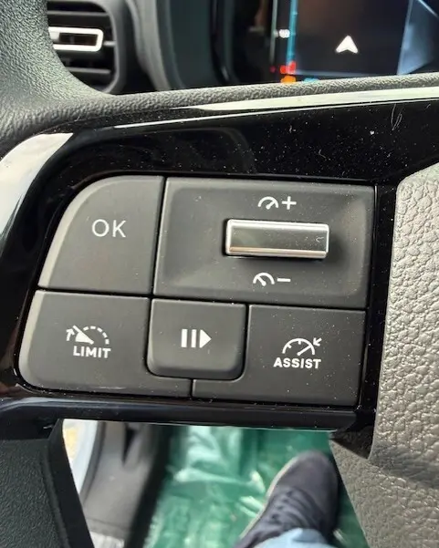 Gros plan sur les commandes au volant noir du Citroën Berlingo blanc 2026, avec boutons de limitation et assistance.