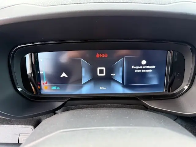 Tableau de bord numérique du Citroën Berlingo blanc 2026, affichant la vitesse à 0 km/h et un message d'alerte.