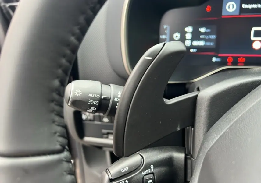 Gros plan sur la palette de changement de vitesse et le commodo d'éclairage du tableau de bord du Citroën C5 Aircross 2025.