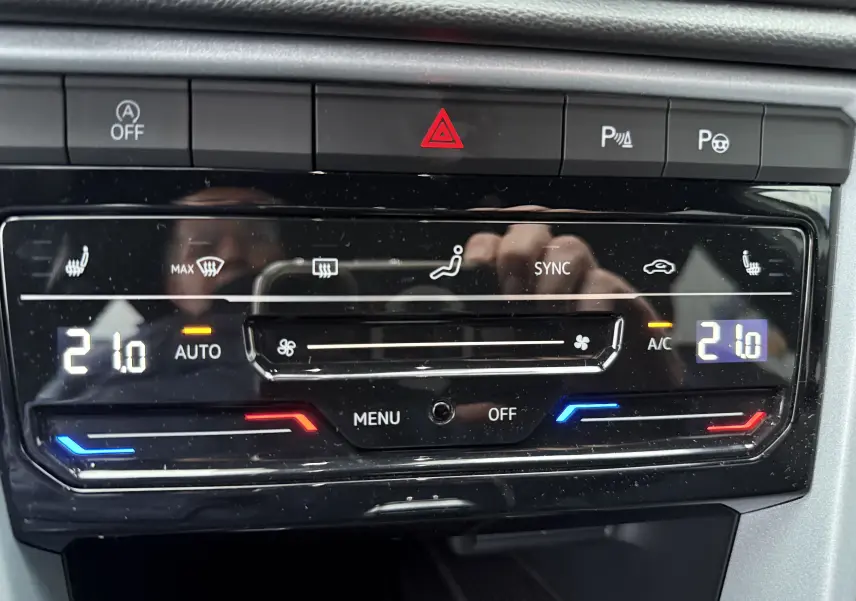 Panneau de commande de la climatisation automatique du Volkswagen T-Roc 2025 avec affichage digital et réglages chauffants.