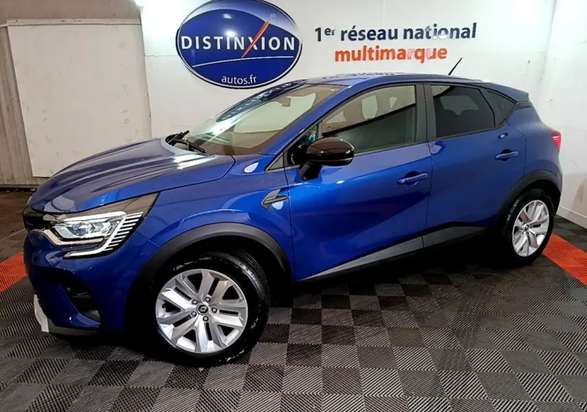 Renault Captur bleu 2023 en vue de profil côté gauche, avec jantes argentées et rétroviseurs noirs.