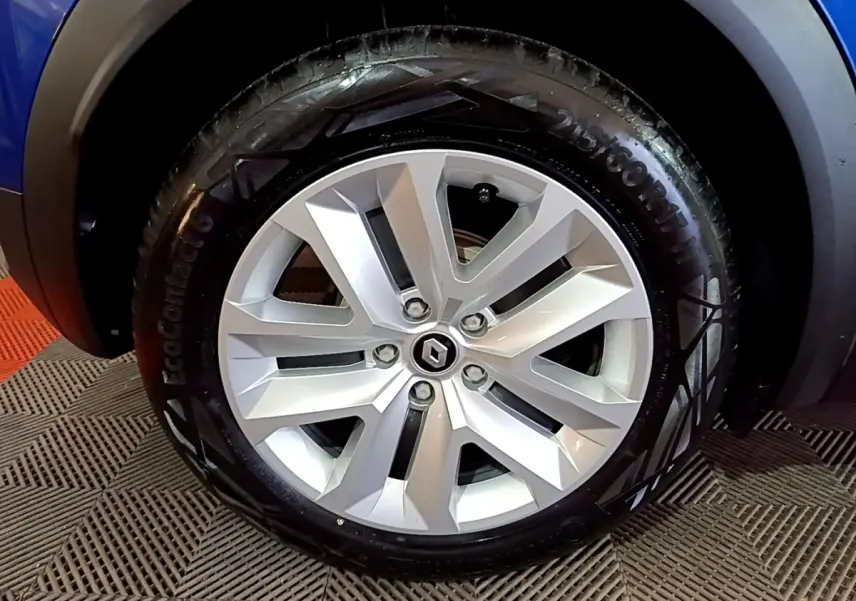 Gros plan sur la roue avant gauche du Renault Captur bleu 2023, mettant en valeur la jante alliage et le pneu EcoContact 6.