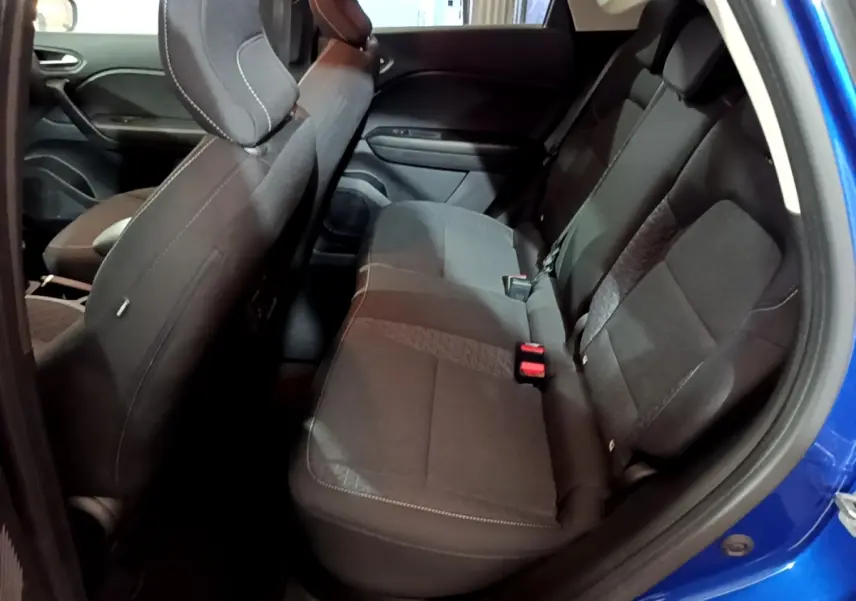 Vue intérieure côté droit des sièges arrière noirs du Renault Captur bleu 2023, banquette 3 places avec ceintures visibles.