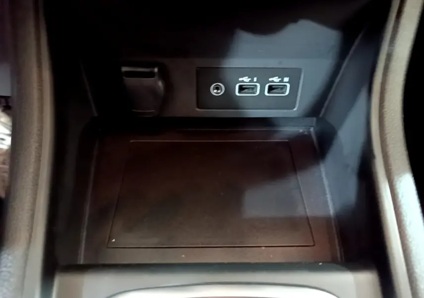 Gros plan sur la console centrale noire du Renault Captur bleu 2023, montrant deux ports USB et une prise jack.