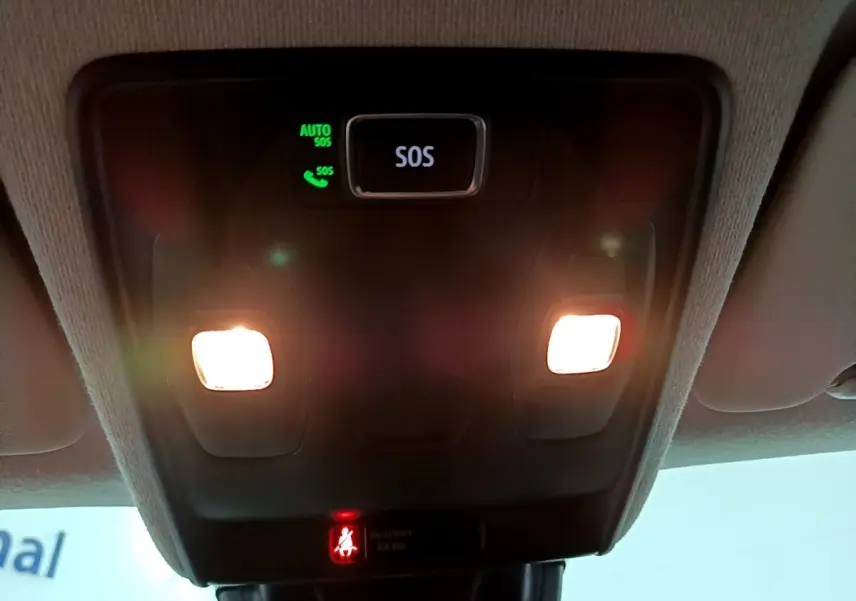 Vue intérieure du plafonnier avec éclairage et bouton SOS allumé dans un Renault Captur bleu hybride 2023.