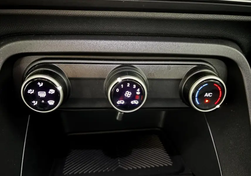 Gros plan sur les commandes de climatisation noire de la Citroën C3 100 BVM PLUS 2025, avec réglages éclairés.