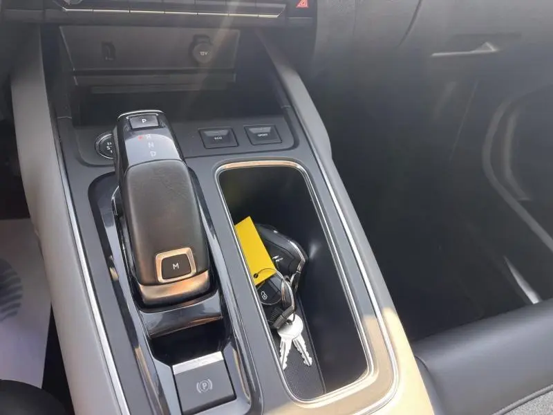 Gros plan sur la console centrale grise du Citroën C5 Aircross 2019 avec levier de boîte auto et clés dans le rangement.