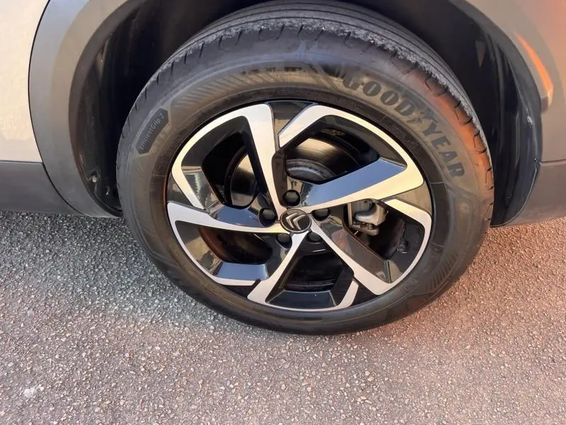 Gros plan sur la jante alliage 18 pouces diamantée noire et argentée du Citroën C5 Aircross gris, pneu Goodyear visible.