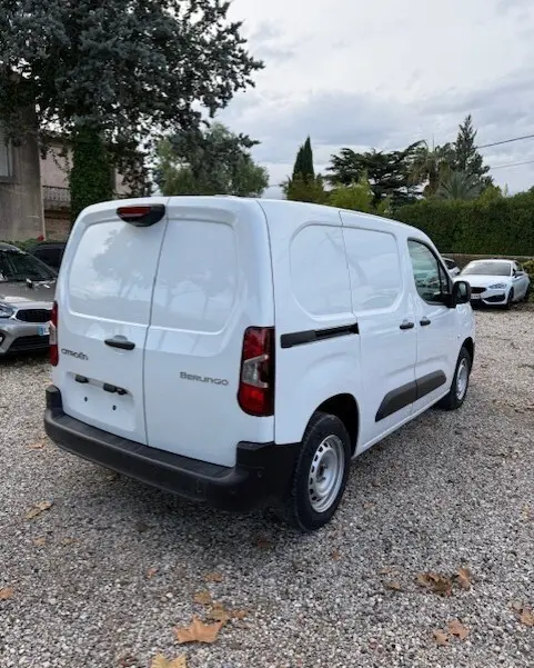 Vue 3/4 arrière droite d'un Citroën Berlingo blanc 2026, version utilitaire avec portes arrière pleines et protections latérales noires.