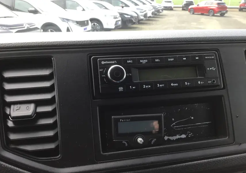 Tableau de bord noir du Volkswagen Crafter 2017 avec autoradio Continental et commande d'aération visible en gros plan.