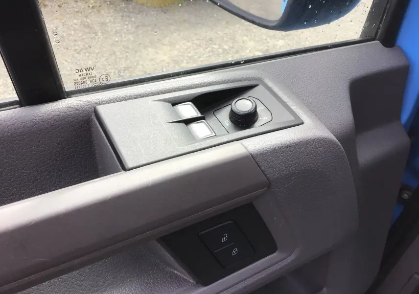Détail de la commande des vitres et rétroviseurs côté conducteur du Volkswagen Crafter bleu 2017, portière ouverte.