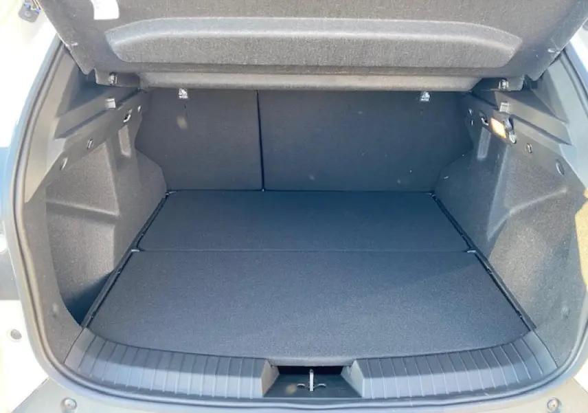 Coffre ouvert du Dacia Duster beige Sandstone 2025, vue intérieure montrant un espace de chargement spacieux et propre.