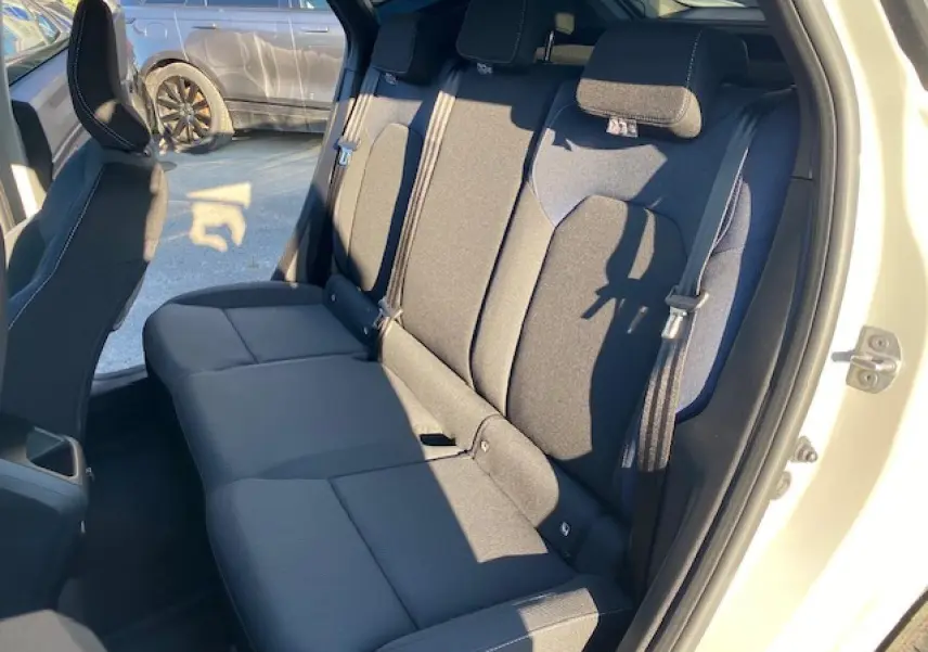 Vue intérieure sur la banquette arrière noire du Dacia Duster beige sandstone 2025, côté droit avec ceinture de sécurité visible.