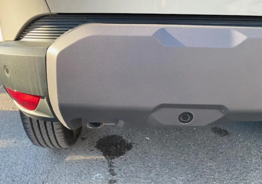 Gros plan sur le pare-chocs arrière beige sandstone du Dacia Duster 2025, avec capteur de recul visible.