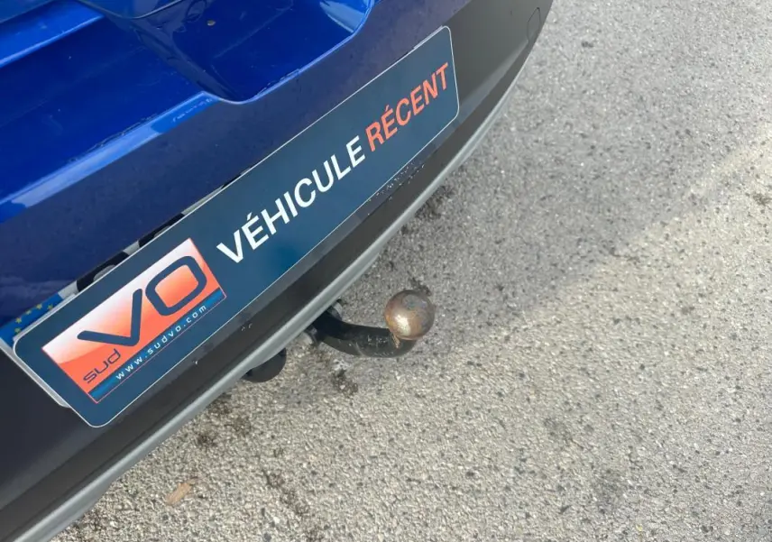 Gros plan sur l'attelage arrière d'une Dacia Sandero Stepway bleu foncé avec plaque "Véhicule récent" visible.