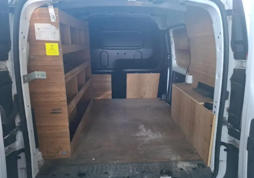 Vue 3/4 arrière droite d’un Renault Kangoo blanc 2020 avec bandes rouges réfléchissantes et plaque Abeilhe Autos.