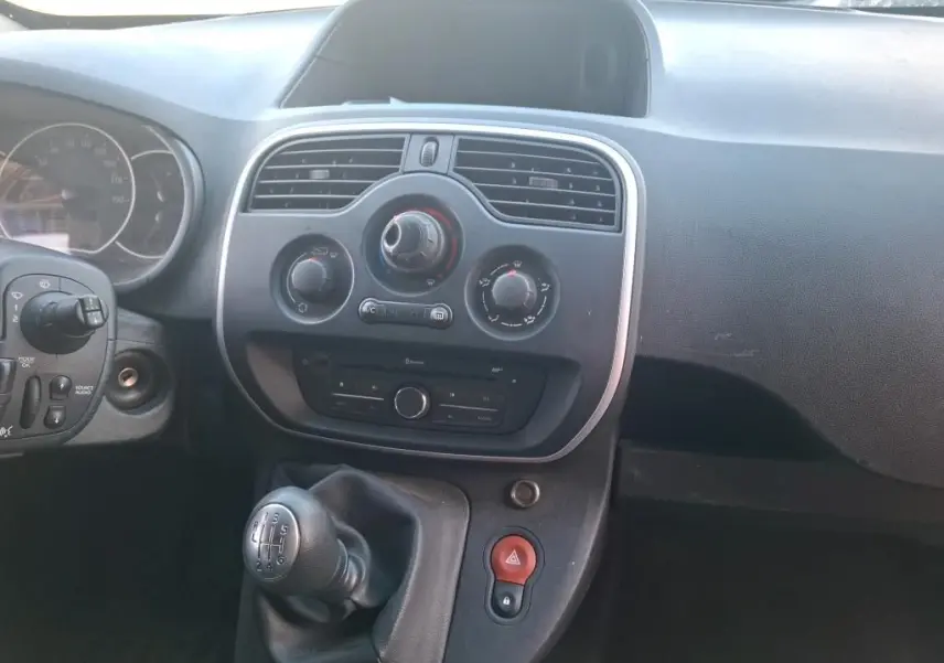 Vue intérieure arrière du Renault Kangoo blanc 2020, montrant les étagères en bois intégrées au compartiment de chargement.