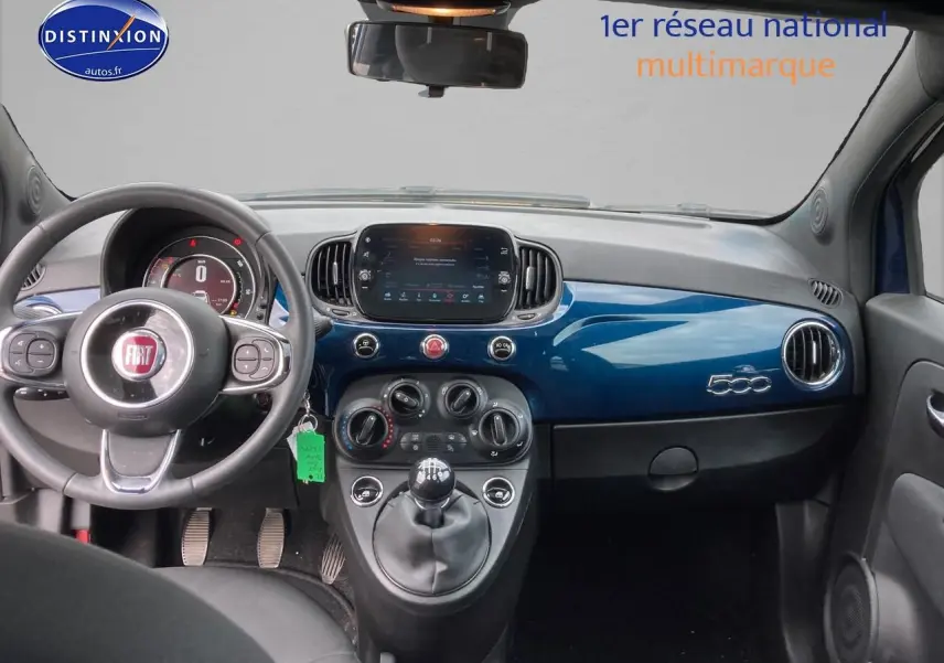 Vue intérieure avant du tableau de bord bleu brillant de la Fiat 500 2023 avec volant multifonction et écran tactile central.