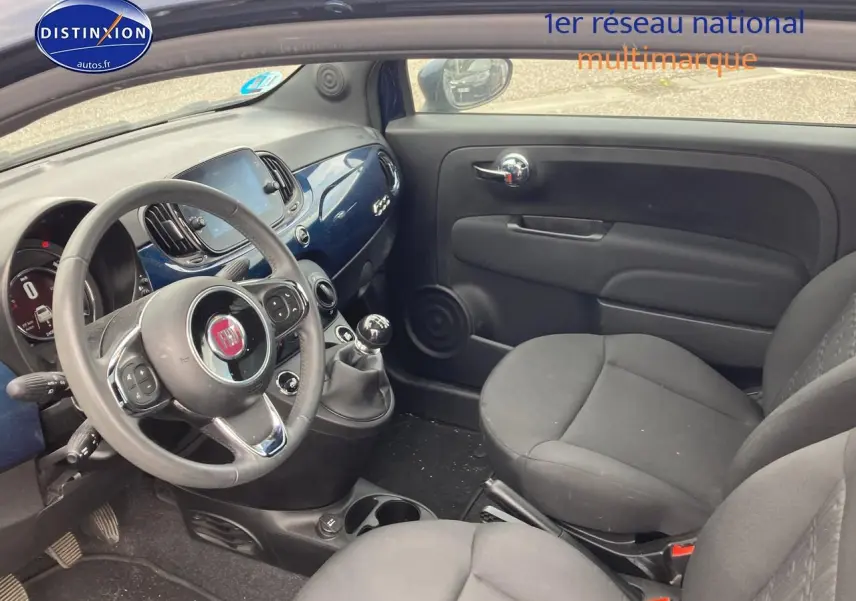 Vue intérieure côté conducteur de la Fiat 500 2023 avec tableau de bord bleu et volant cuir multifonction.