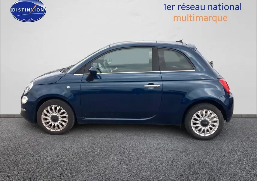 Profil latéral gauche d'une FIAT 500 bleu foncé 2023 avec jantes alu et toit panoramique en verre.