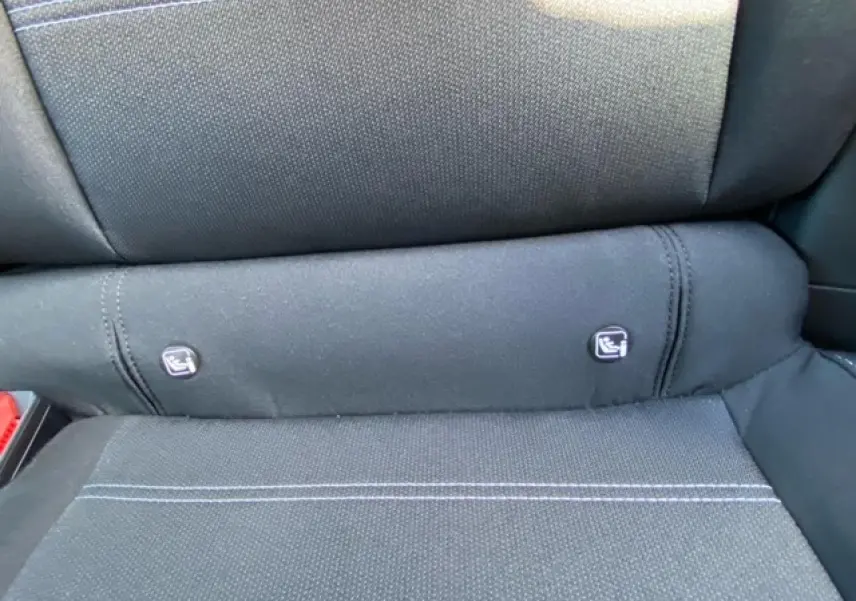 Détail des fixations Isofix sur la banquette arrière en tissu noir de la Dacia Logan 2022 gris.