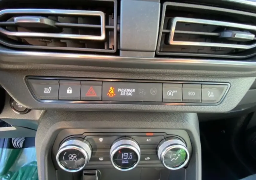 Détail du tableau de bord de la Dacia Logan 2022, montrant les commandes de climatisation automatique et les boutons de sécurité.