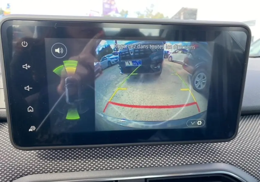 Écran tactile Media Nav montrant la caméra de recul active avec vue arrière et alertes radar sur Dacia Logan gris.