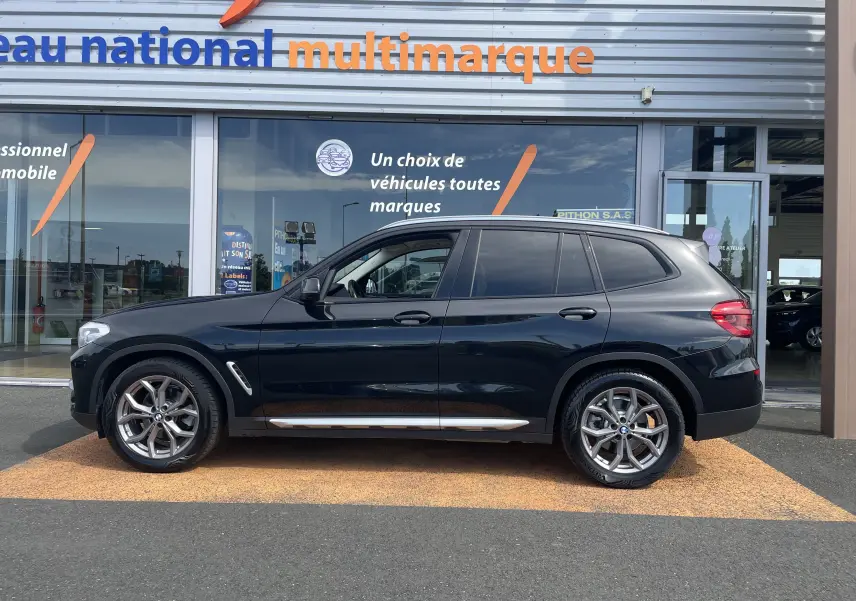 BMW X3 noir vue de profil côté gauche, avec jantes alliage et détails chromés sous les portes.