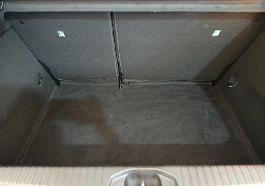 Coffre ouvert de la Renault Clio Evolution TCe 90 2023, vue intérieure, revêtement noir et banquette rabattue.