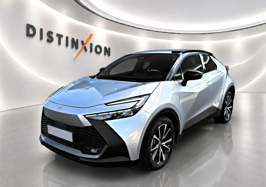 Toyota C-HR gris 3/4 avant droit avec toit noir et jantes alliage dans un showroom lumineux.