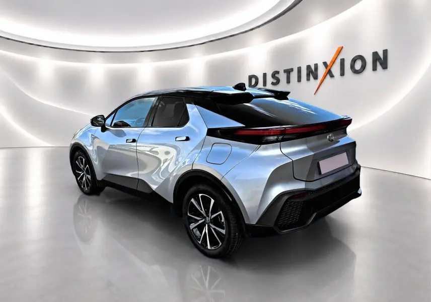 Toyota C-HR 1.8 hybride gris en 3/4 arrière droit, avec toit noir et feux arrière LED fins.