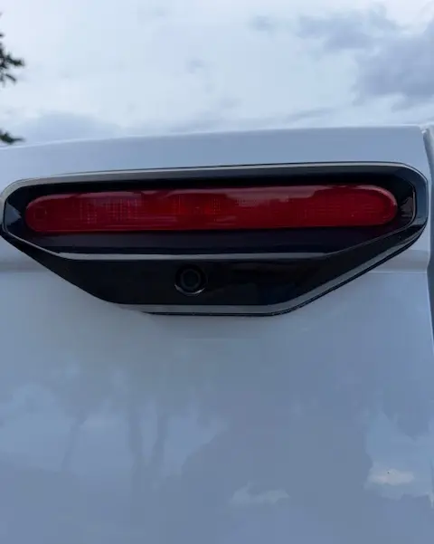 Gros plan sur le feu arrière rouge et la caméra de recul du Citroën Berlingo Van M Diesel blanc, vue arrière.