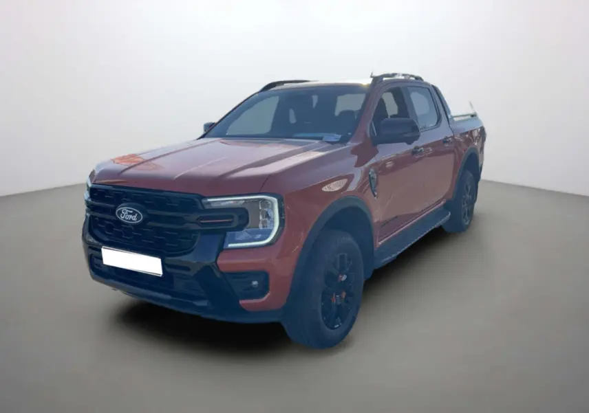 Ford Ranger Wildtrak orange Ignite vu en 3/4 avant droit avec jantes noires et barres de toit.