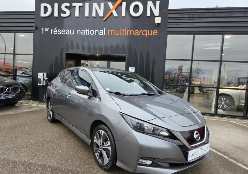 Nissan Leaf II gris foncé métallisé vue 3/4 avant droit devant un showroom Distinxion.