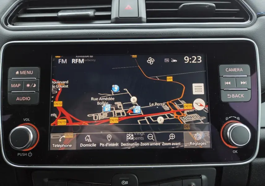 Écran central tactile du tableau de bord de la Nissan Leaf II gris foncé, affichant la navigation GPS en mode jour.