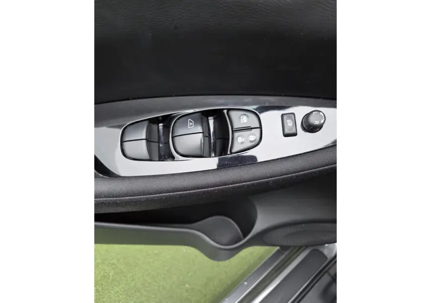 Gros plan sur les commandes de lève-vitres et rétroviseurs côté conducteur du Nissan Leaf gris foncé 2021.