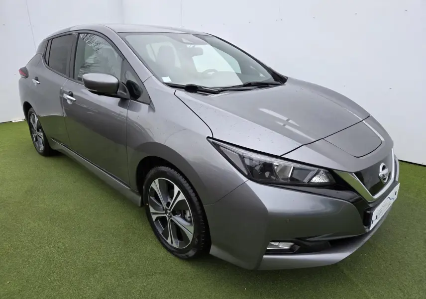 Nissan Leaf II gris foncé métallisé vue 3/4 avant droit sur sol vert avec phares LED et jantes alliage.