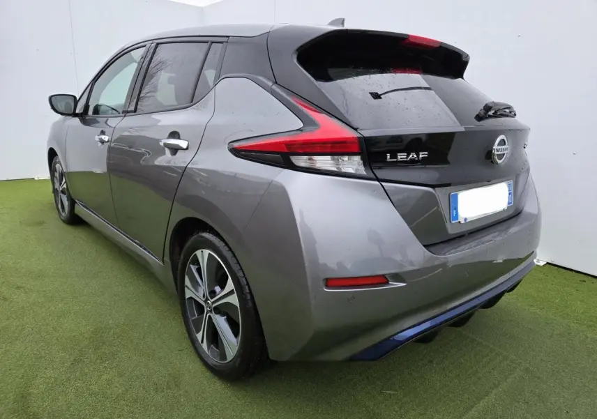 Vue 3/4 arrière droite d'une Nissan Leaf II gris foncé métallisé avec feux arrière LED et jantes alliage.