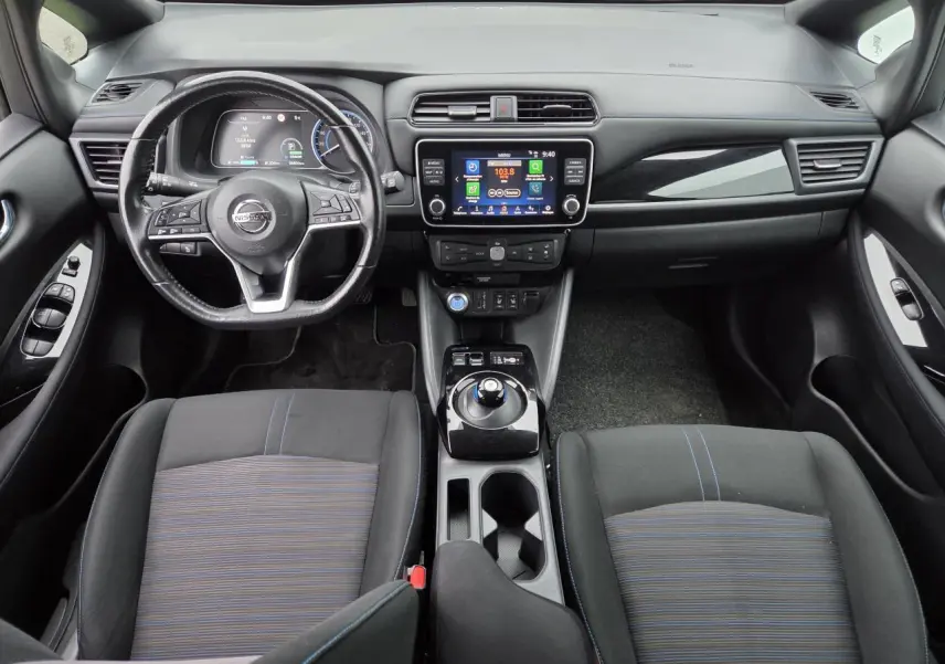 Vue intérieure avant du Nissan Leaf II gris foncé, avec tableau de bord numérique et volant cuir multifonction.